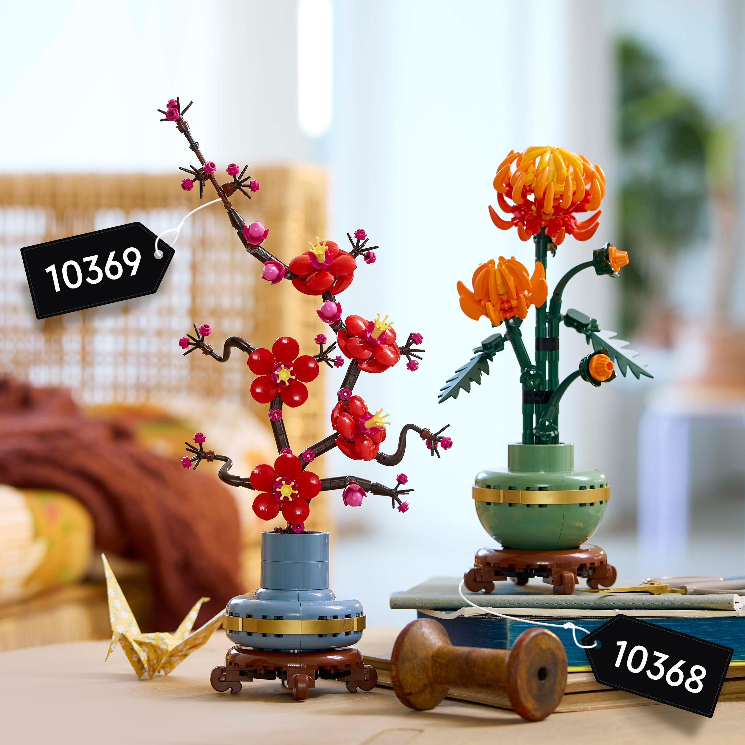 Zwei LEGO-Blumensets, die auf einem Holztisch ausgestellt sind.