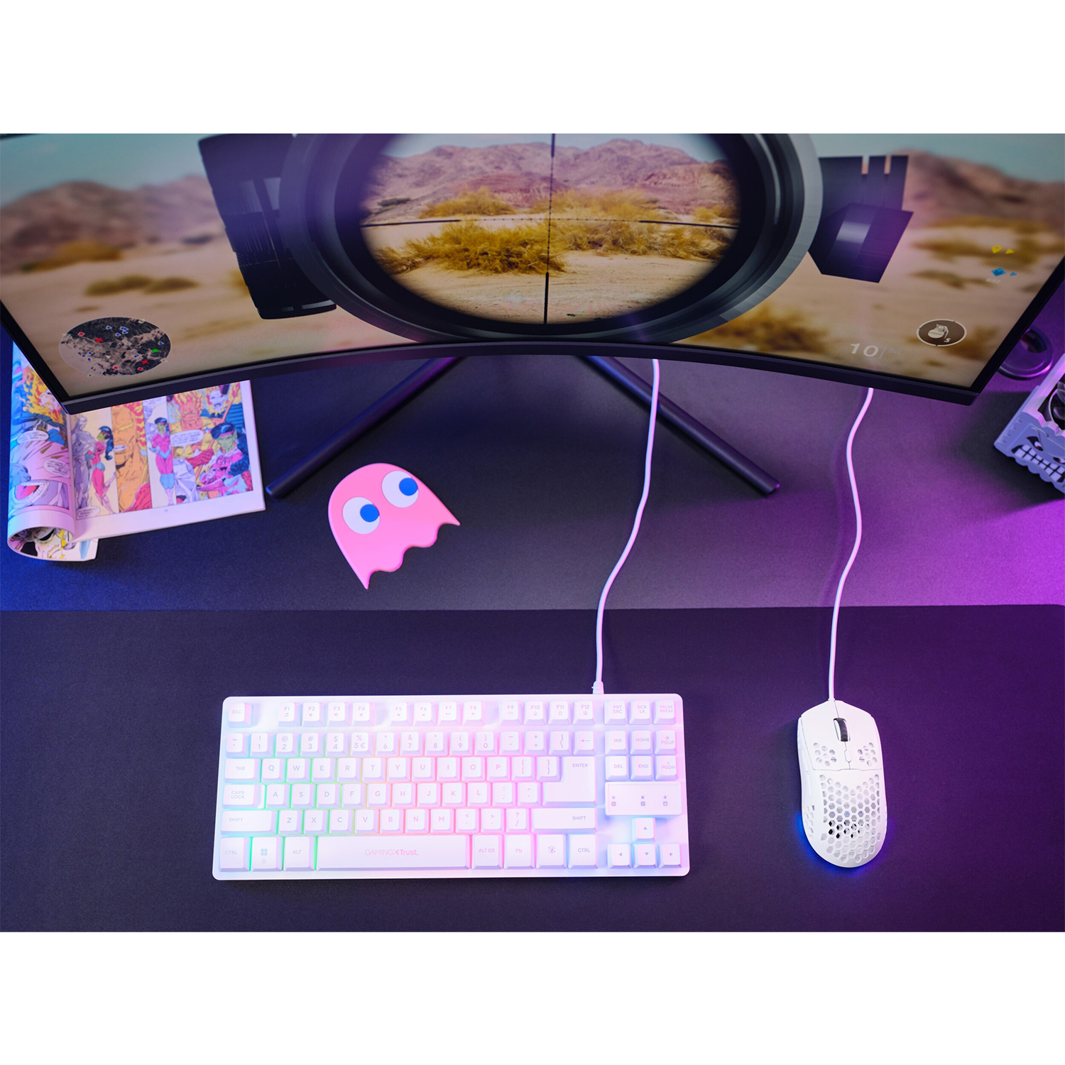 Configurazione scrivania con tastiera gaming, mouse e monitor curvo che mostra una scena di gioco.