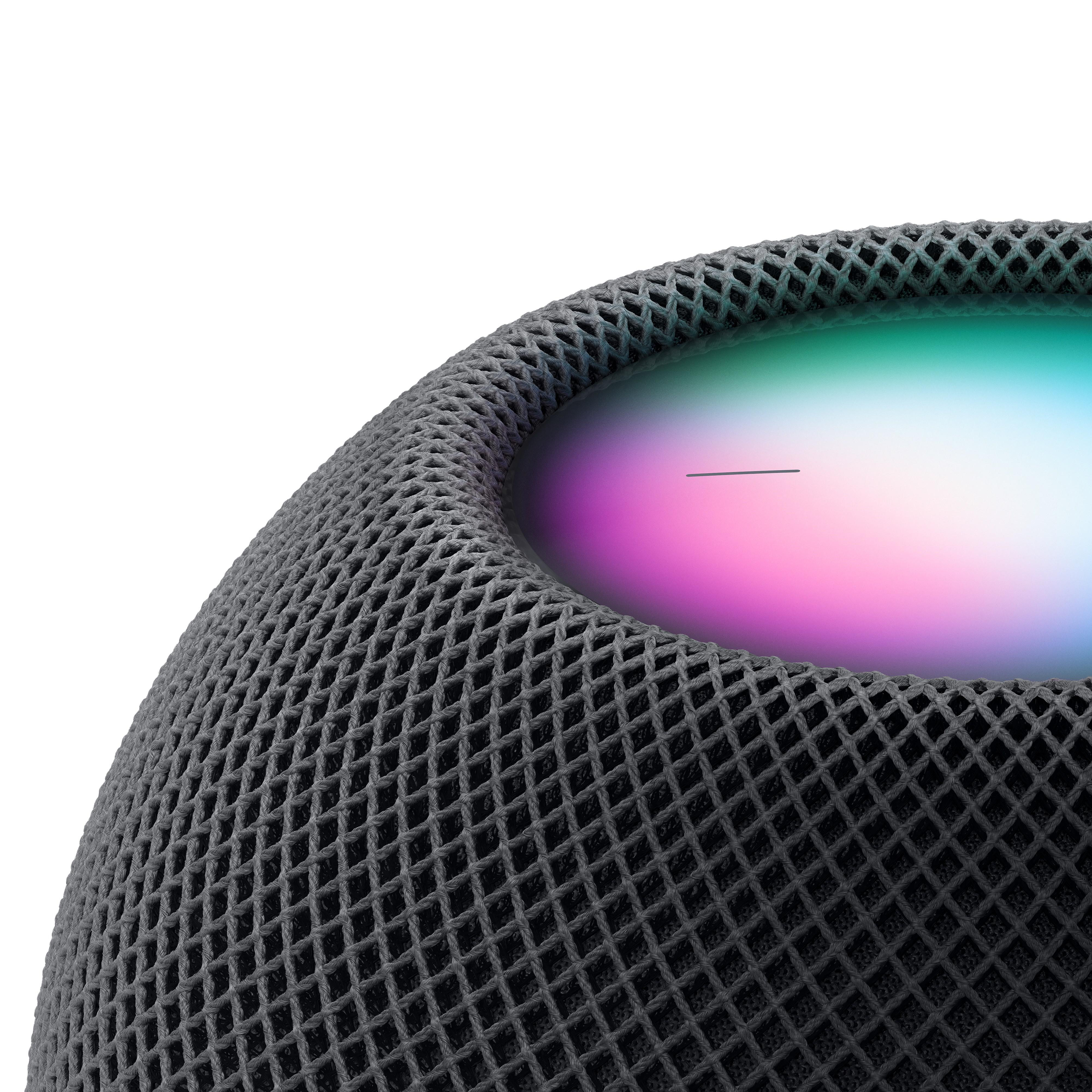 Nahaufnahme eines grauen, mit Mesh bedeckten Smart Speakers. Buntes Licht von oben.