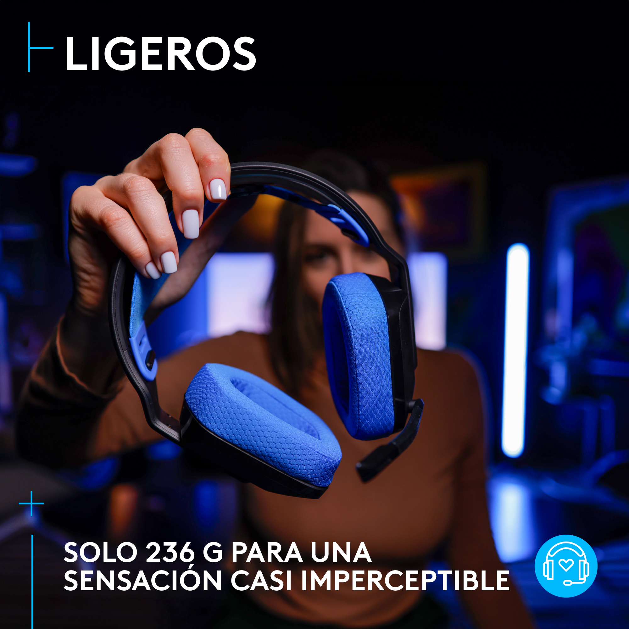Mujer sosteniendo auriculares para juegos. Los auriculares son azules y negros. Fondo oscuro con luces azules.
