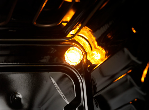 Interior of an oven with a bright orange light illuminating the inside.