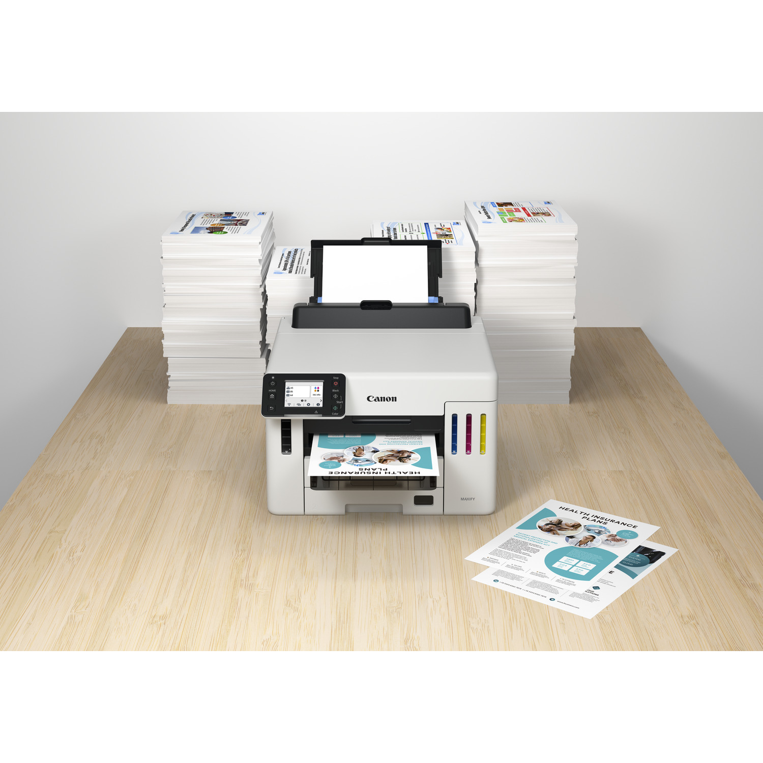 Imprimante Canon blanche imprimant un document coloré, piles de papier à côté.