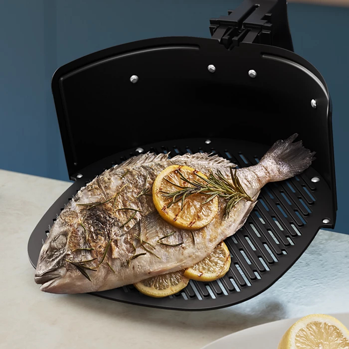 Gotowana ryba z plastrami cytryny i rozmarynem w frytkownicy beztłuszczowej.