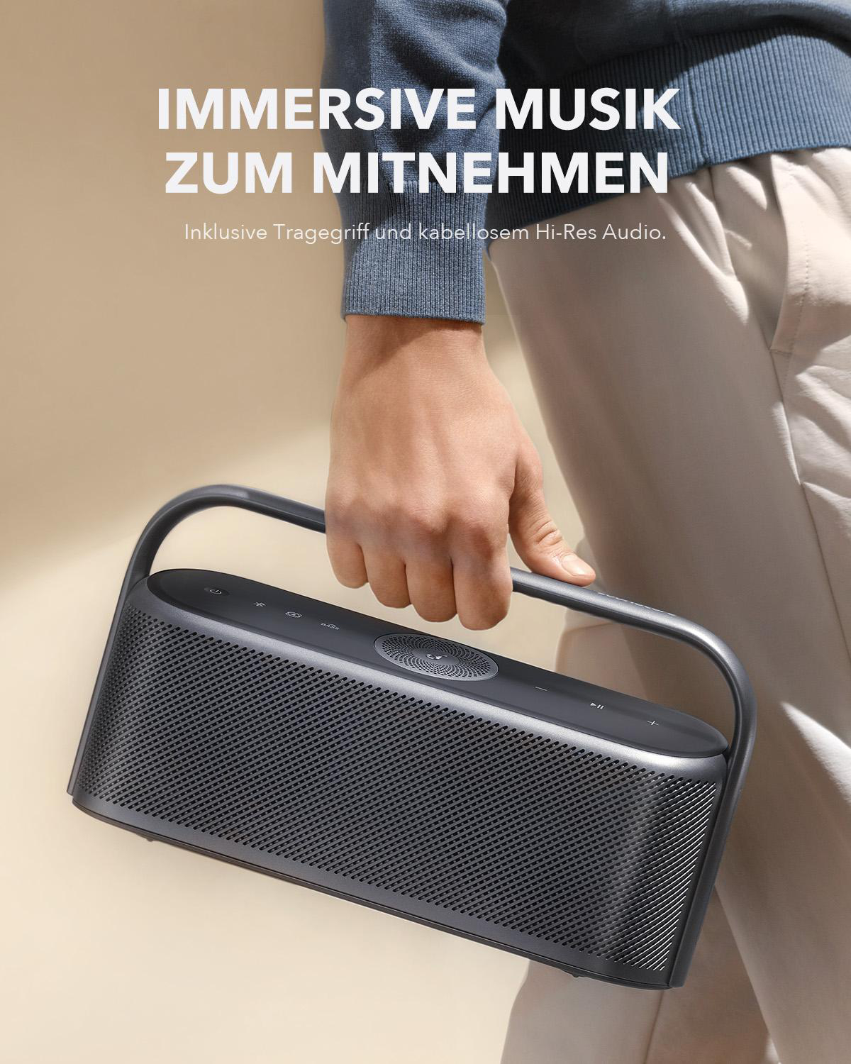 Eine Person hält einen grauen tragbaren Lautsprecher. Text sagt 'Immersive Music To Go'.