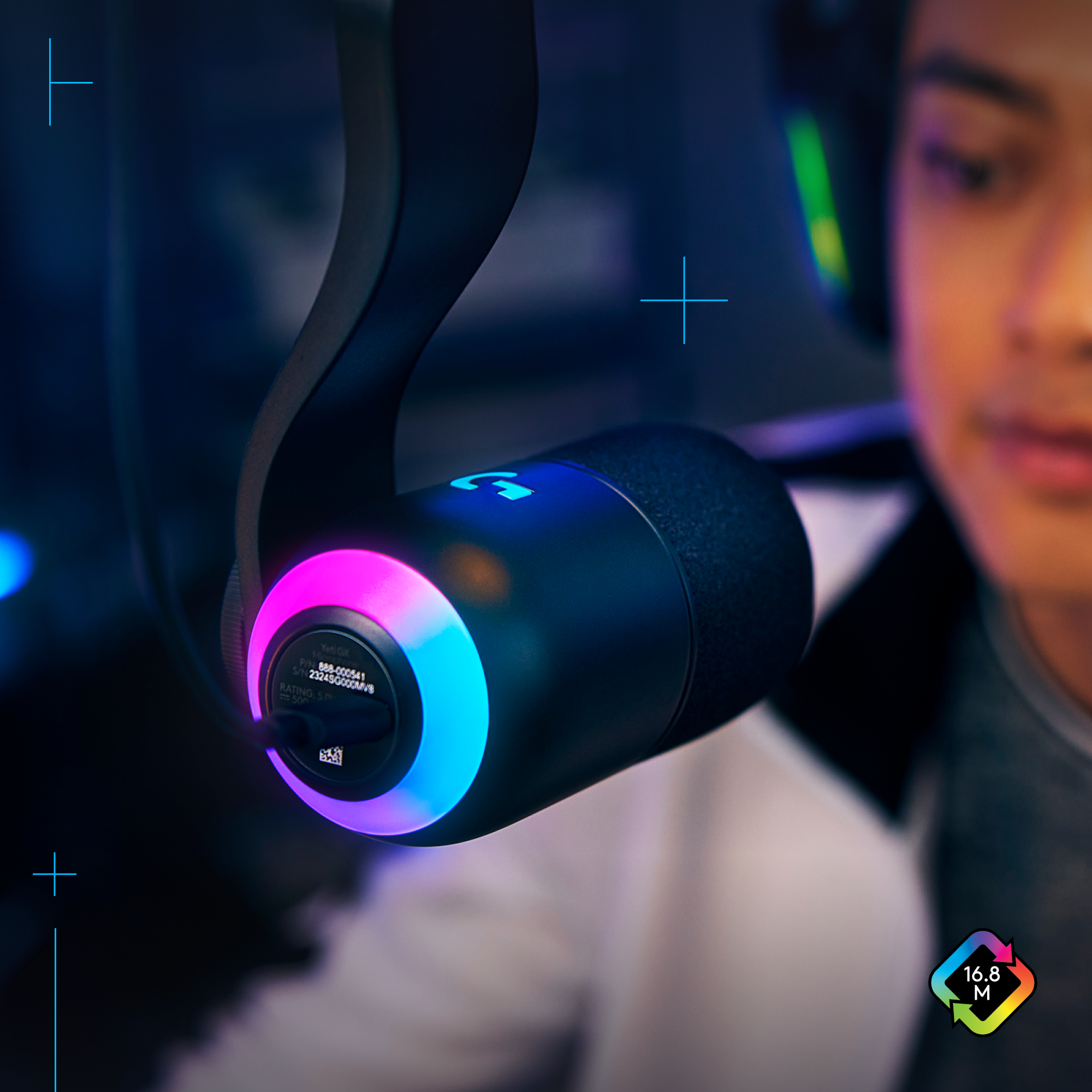 Primer plano de auriculares gaming con luces azules y rosas, persona borrosa al fondo.