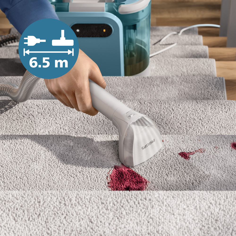 Een persoon gebruikt een Philips stoomreiniger op een trap met tapijt om rode vlekken te verwijderen.
