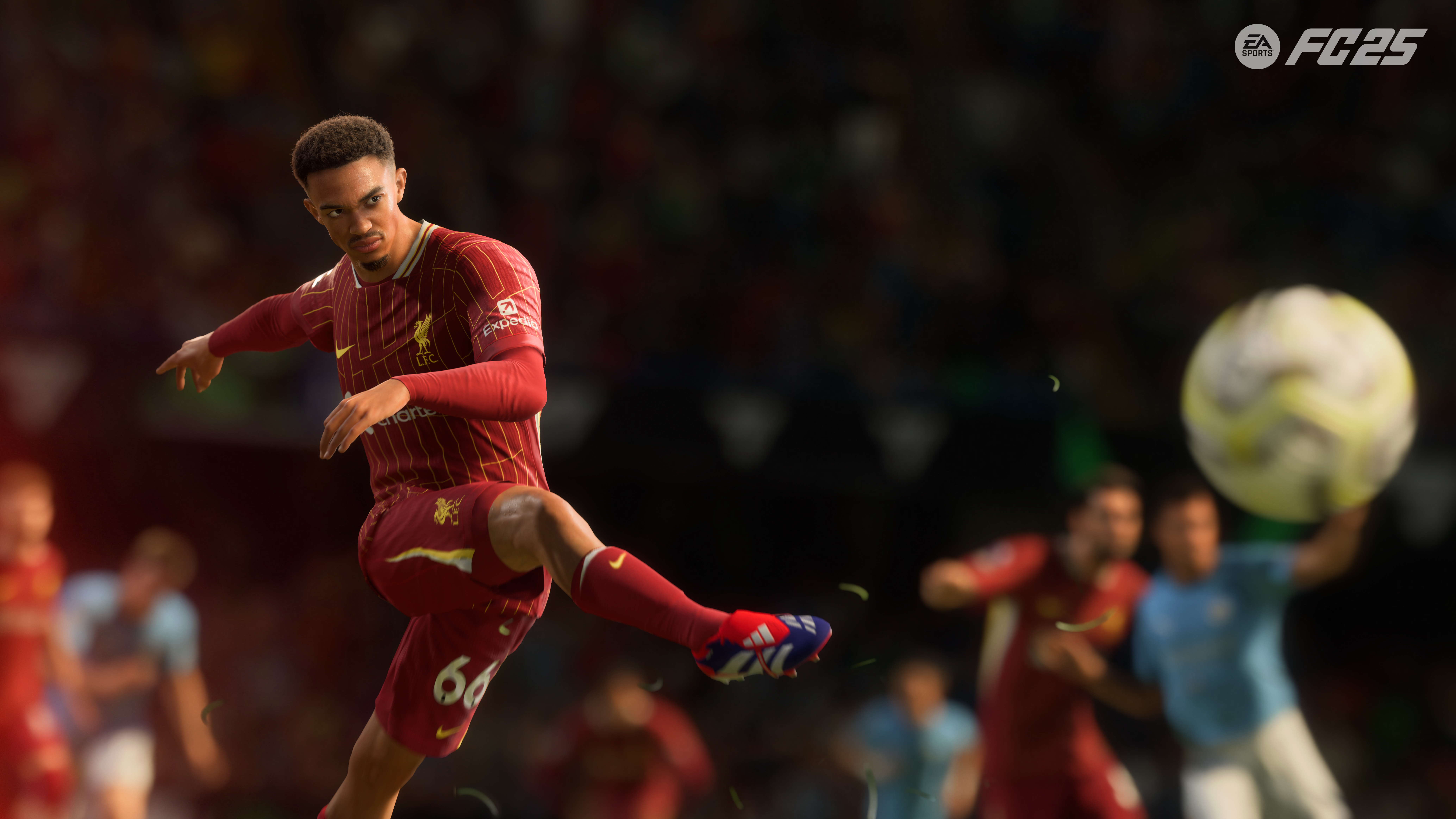 Footballeur en tenue de Liverpool frappant le ballon dans un stade.