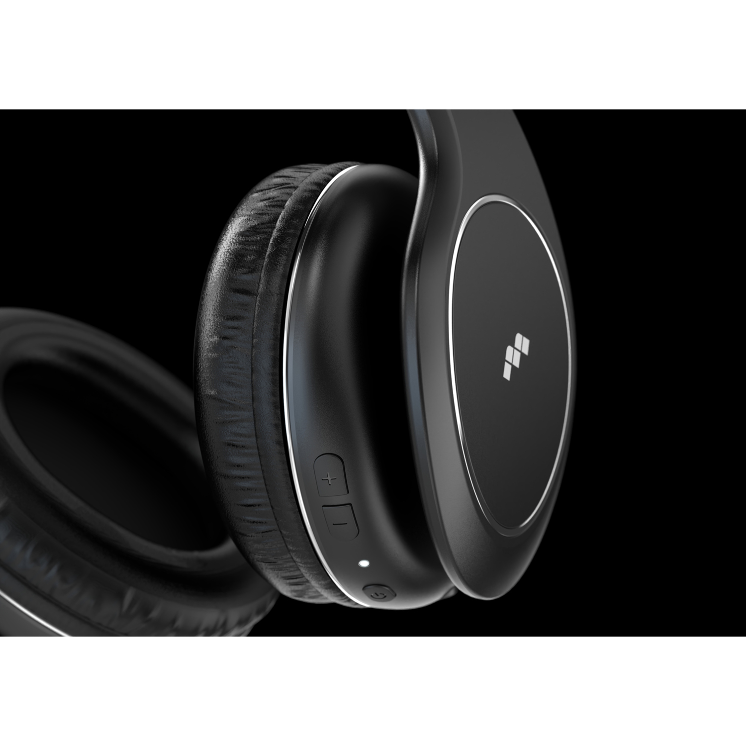 Primo piano di cuffie wireless nere con dettagli argento su sfondo nero.