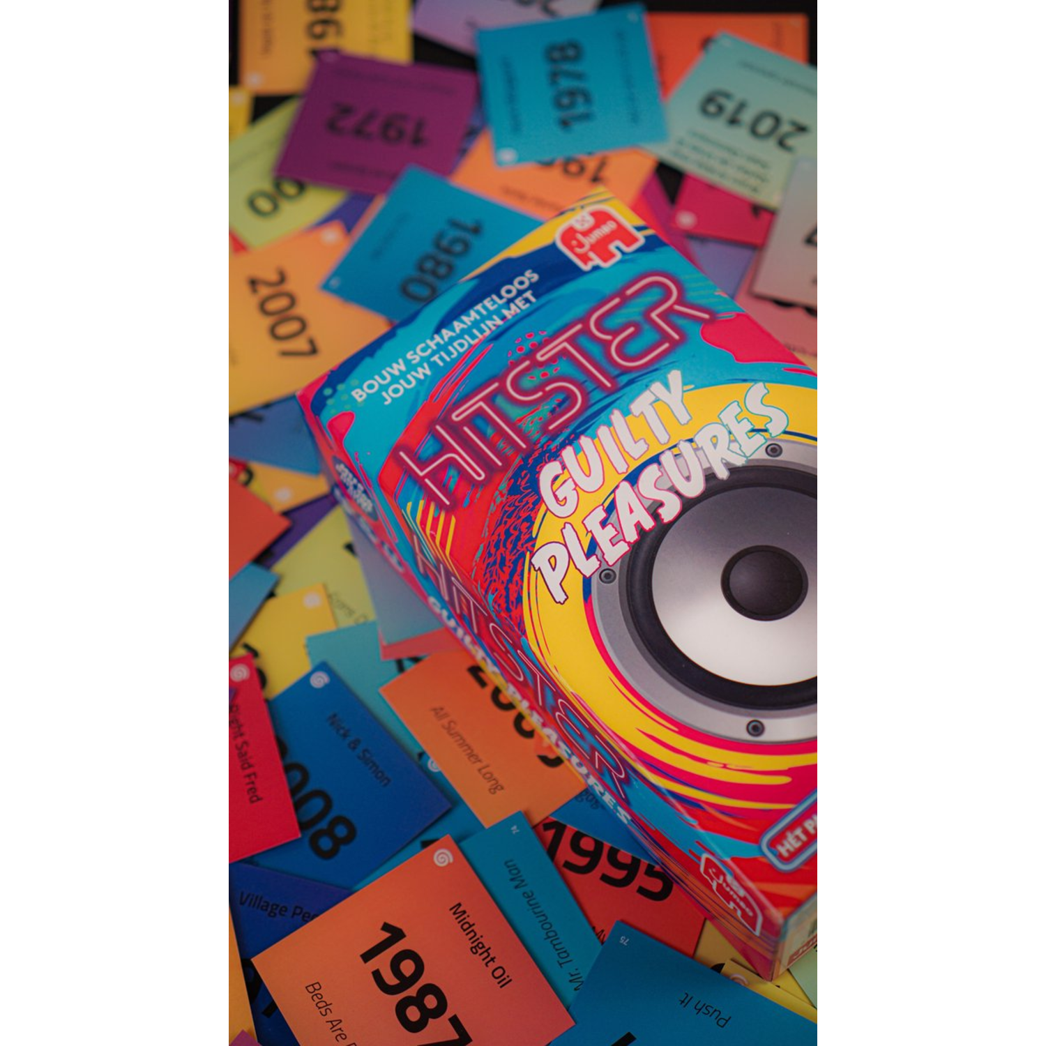 Doos van het spel 'Hitster Guilty Pleasures' met kaarten en een kleurrijke achtergrond.