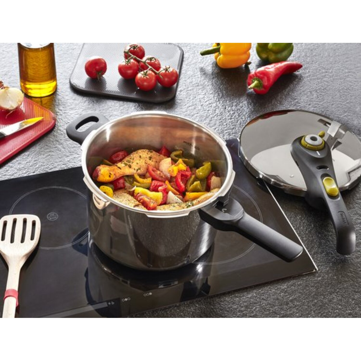 A stainless steel pressure cooker with food is on a stovetop with other cooking items.