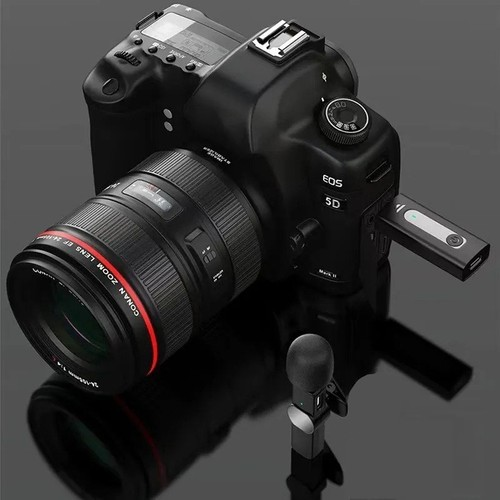 Bir lens ve bir mikrofon takılı siyah bir kamera. Bir USB sürücüsü takılı. Arka plan: siyah yüzey.