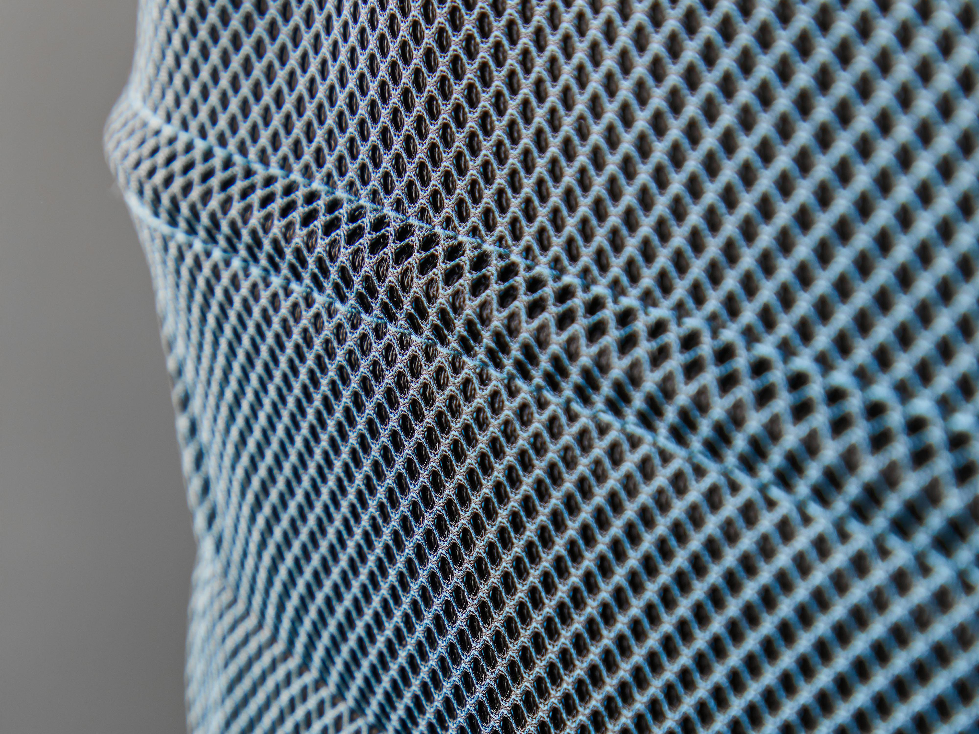 Nahaufnahme von blauem und schwarzem Mesh-Gewebe. Das Netz hat kleine, rautenförmige Löcher.