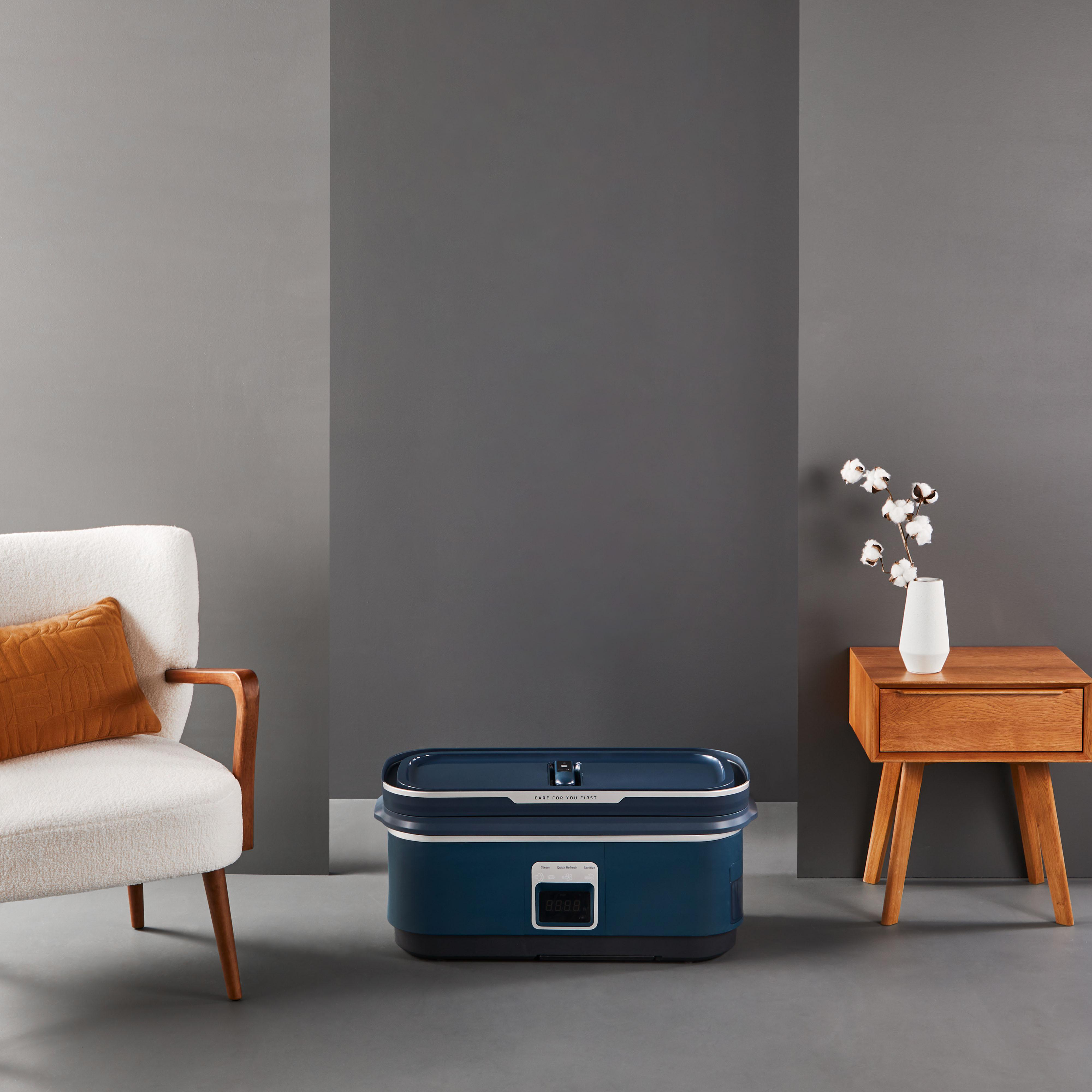 Blau-dunkelblaue Aufbewahrungsbox, weiße Vase und ein Stuhl mit braunem Kissen.