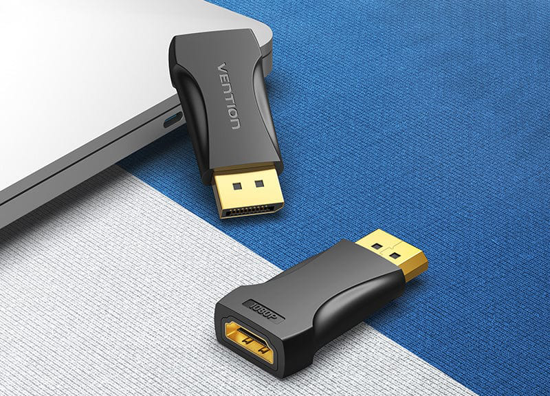 Két fekete-arany adapter kék-fehér felületen, egy laptopon.