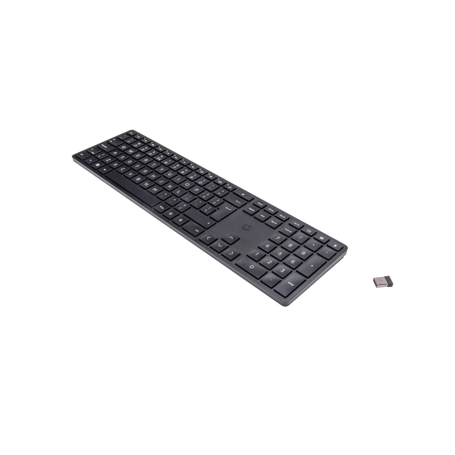 A black keyboard and a small receiver on a black surface. The keyboard has a standard layout.