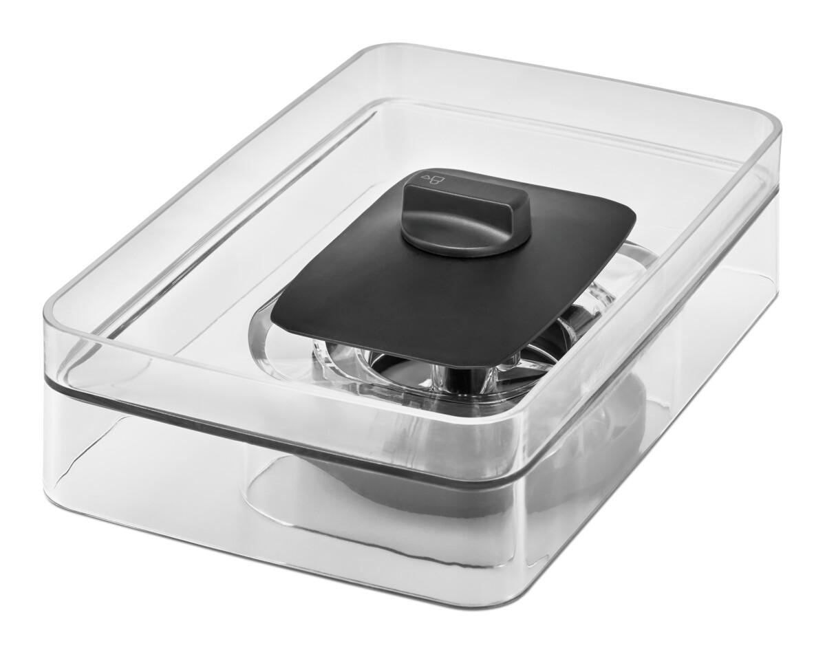 Transparenter Kunststoffbehälter mit schwarzem Deckel und silbernem Mechanismus innen. Weißer Hintergrund.