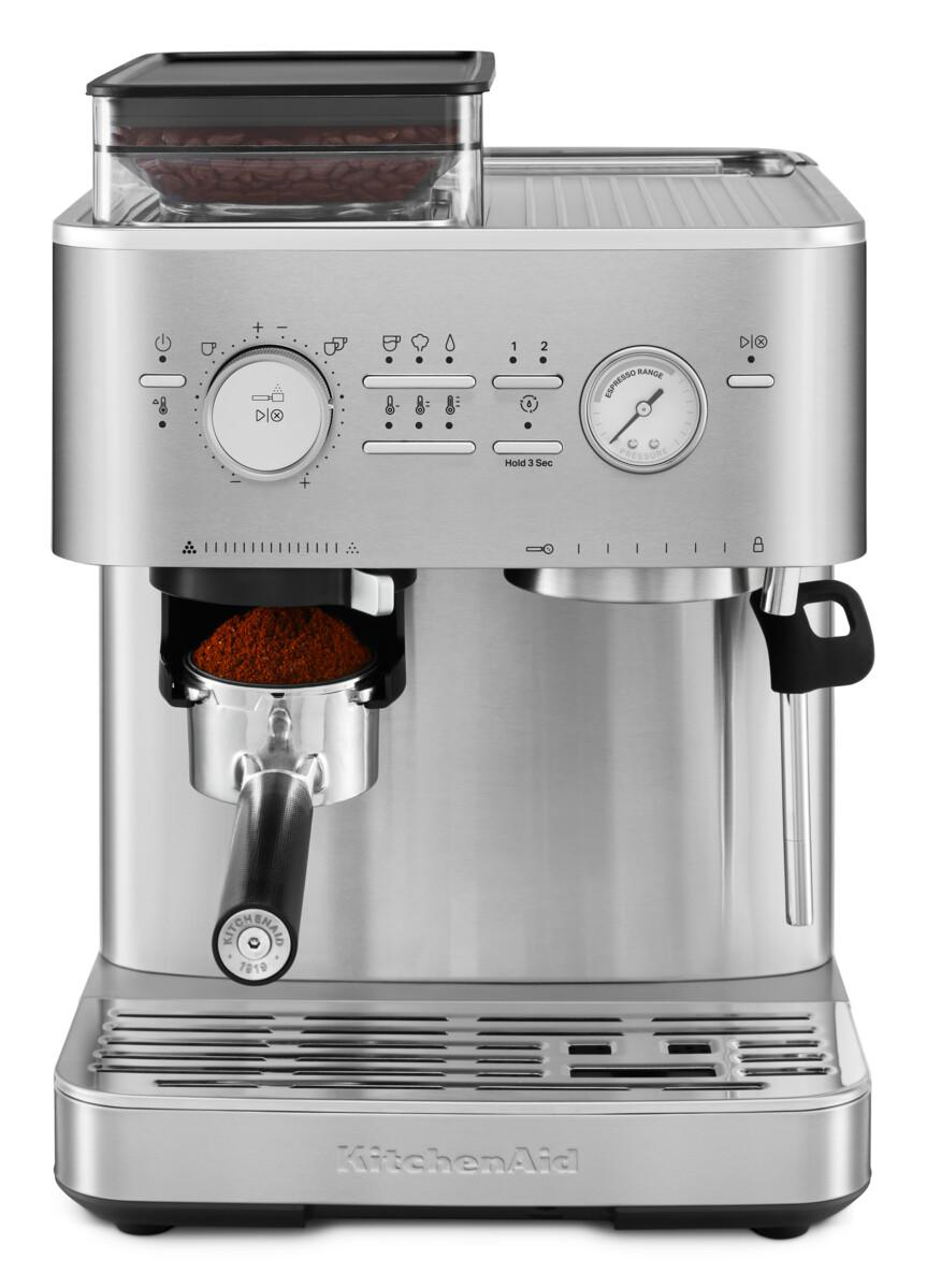 Edelstahl KitchenAid Espressomaschine mit Mahlwerk. Kaffee im Siebträger, Drehregler und Knöpfe sichtbar.