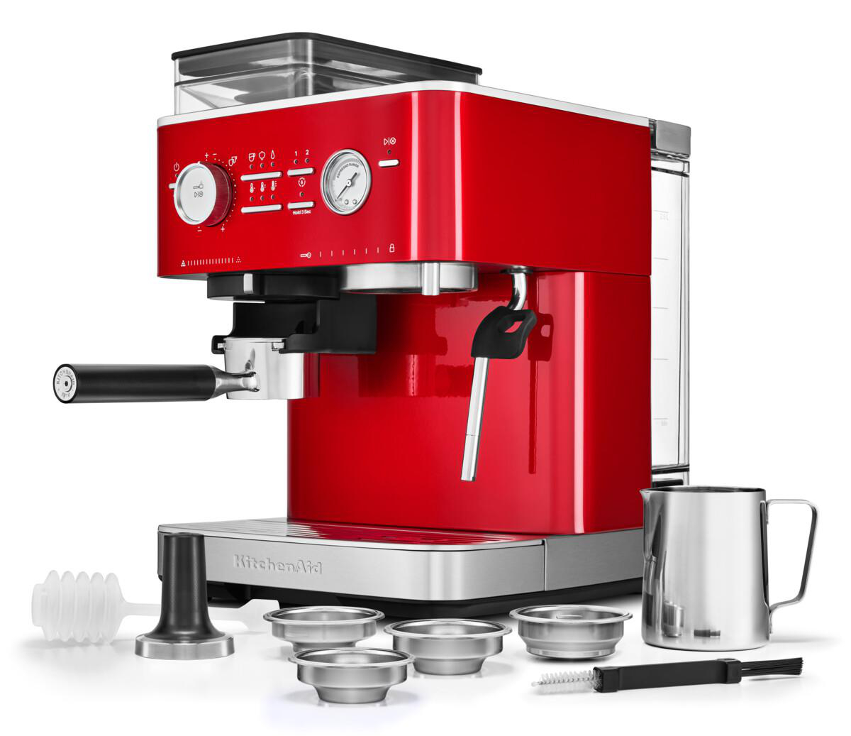 Eine rote KitchenAid Espressomaschine mit Zubehör. Sie hat einen Siebträger und eine Milchaufschäumdüse.
