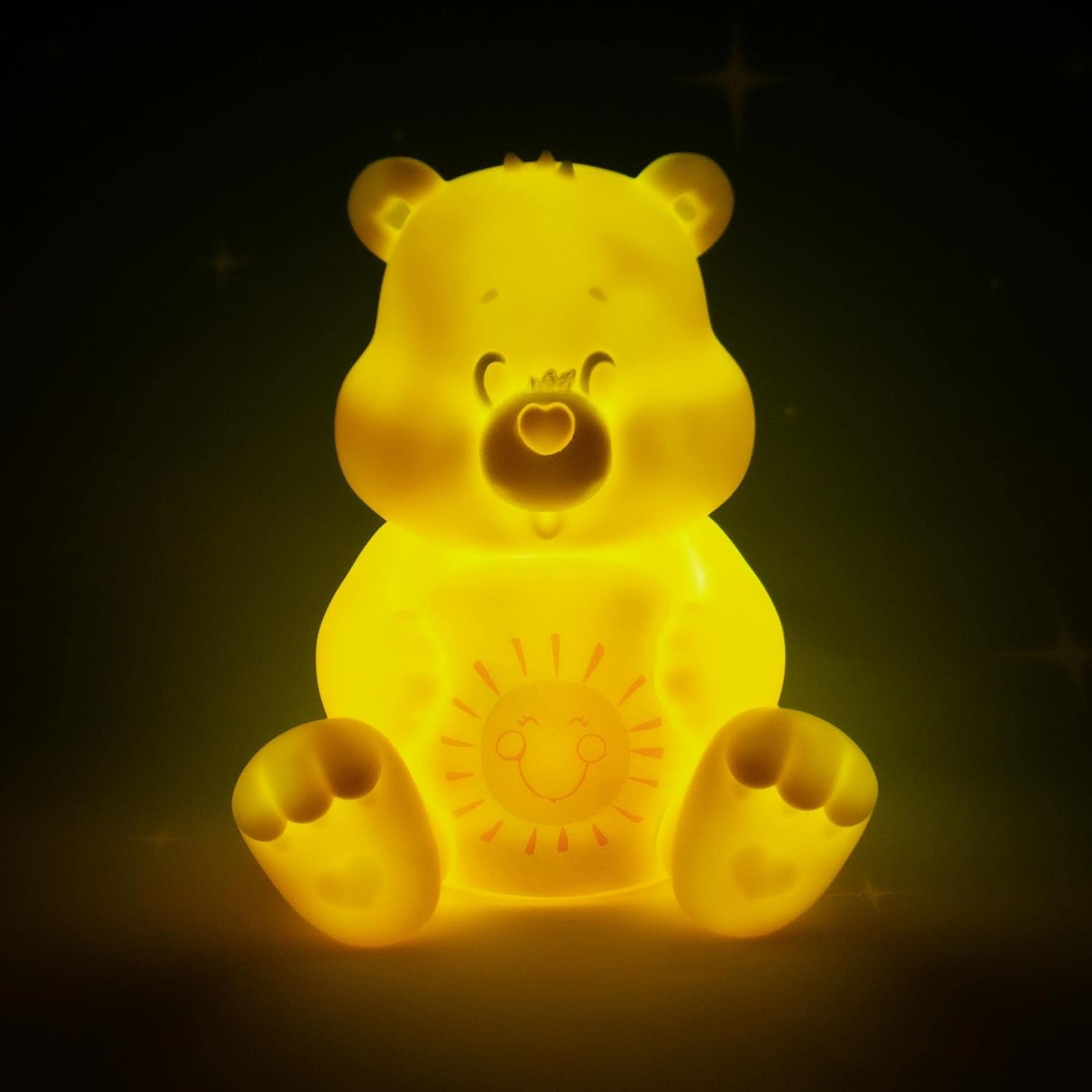 Une veilleuse Care Bear jaune brille dans le noir.
