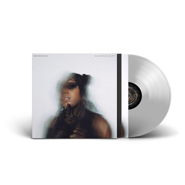 Eine Vinyl-Schallplatte in einer Hülle. Auf der Hülle stehen der Albumtitel 'Defences' und 'Shadowlight'.