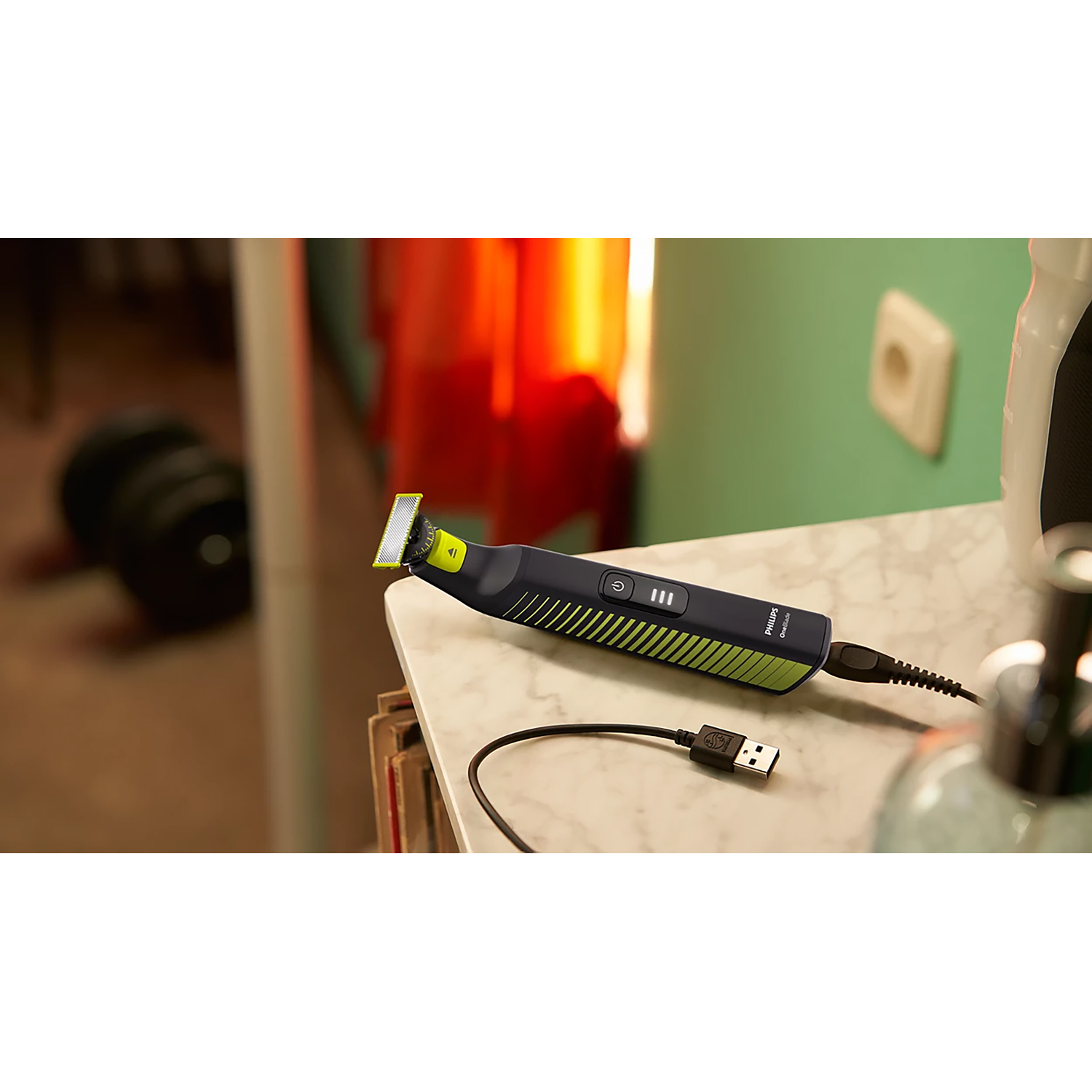 Regolabarba su superficie in marmo. Design nero e verde. Cavo USB collegato.