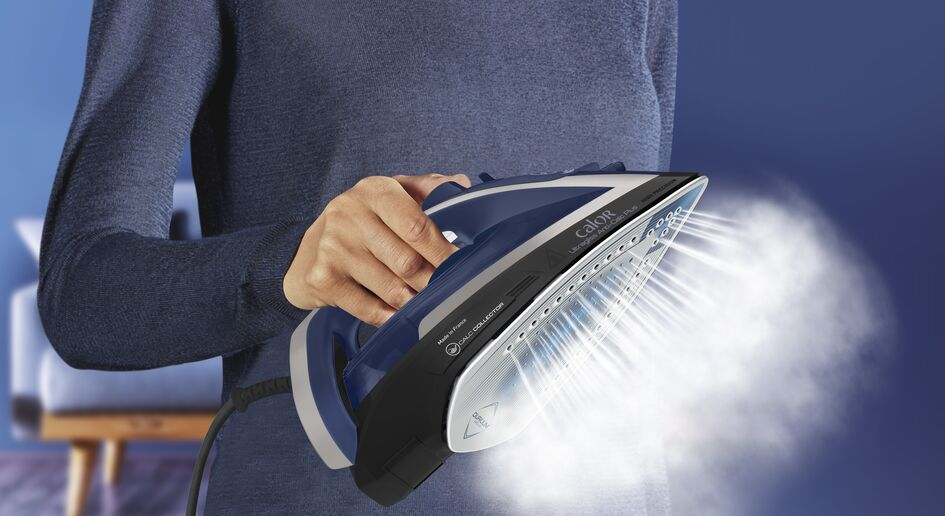 Une personne repassant avec un fer bleu, dégageant de la vapeur. Un fond bleu et un canapé.