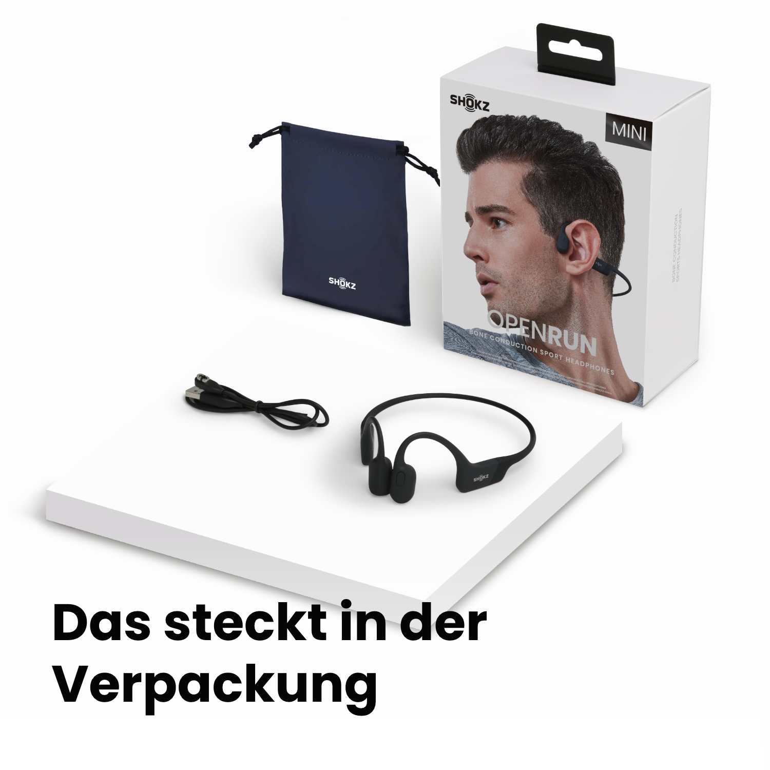 Box mit Kopfhörern, Beutel und Kabel. Box zeigt Mann mit Kopfhörern. Text: Openrun, Shokz. Weiße Oberfläche.