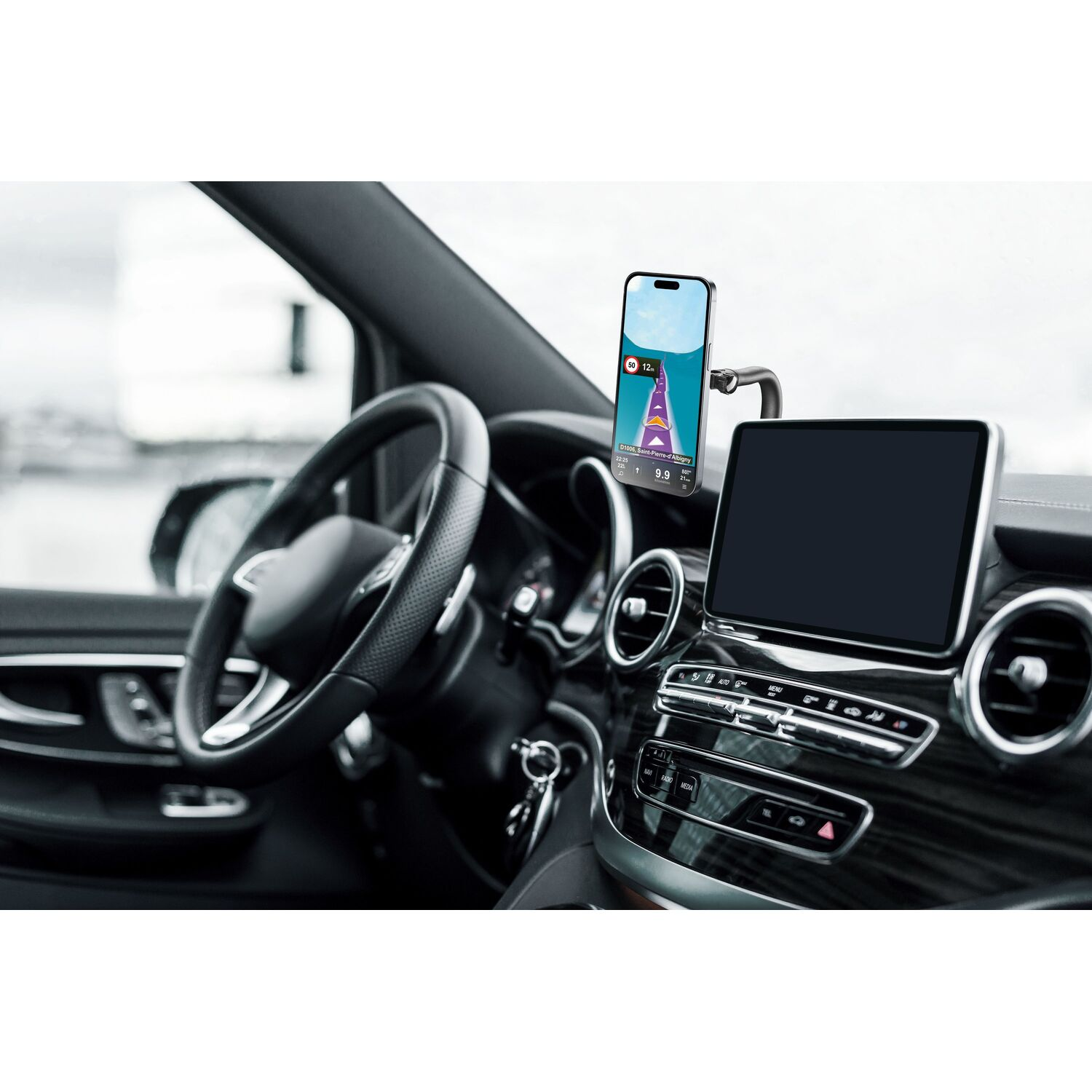 Un smartphone affichant une carte est dans le tableau de bord d'une voiture.
