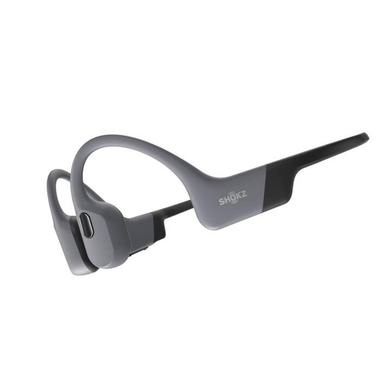 Casque Shokz gris. Ce sont des écouteurs à conduction osseuse, gris et noirs.