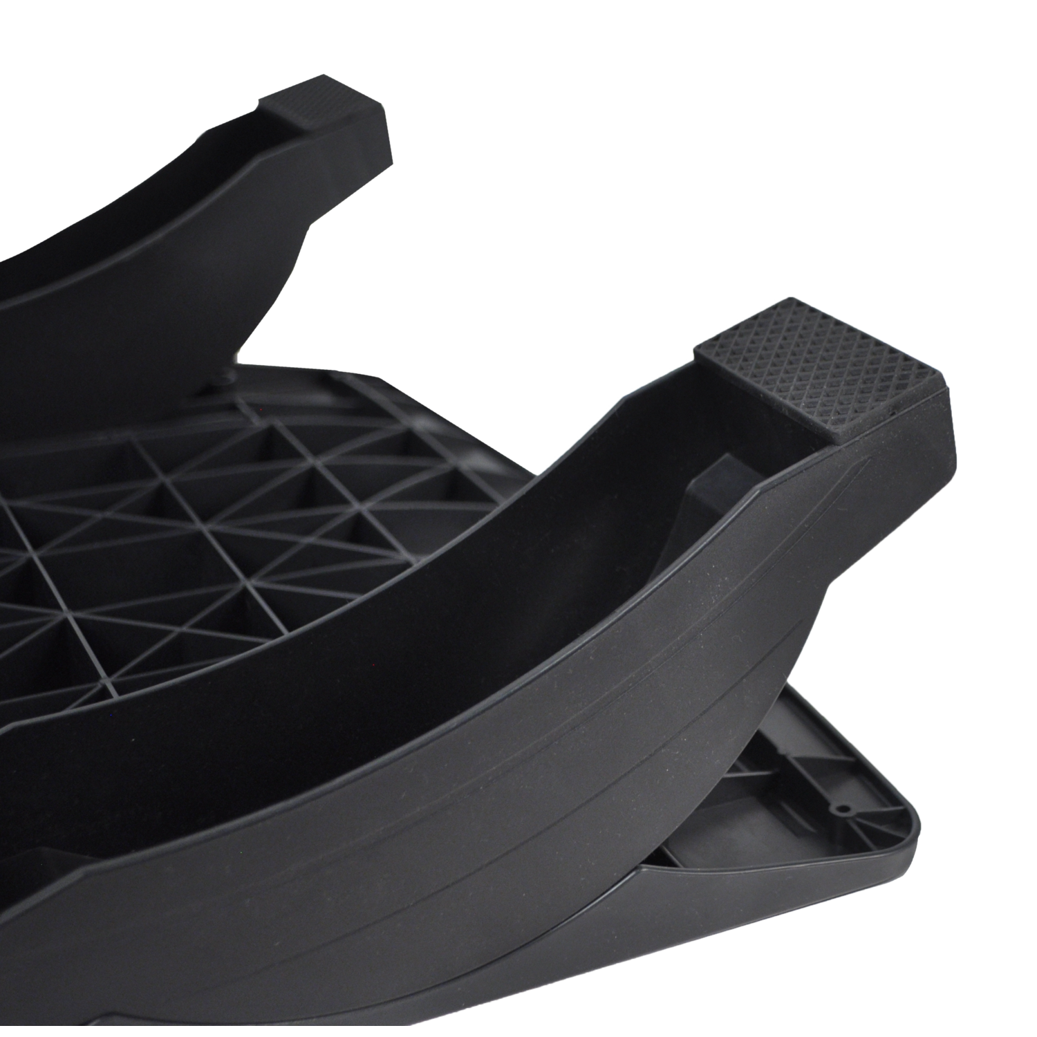 Close-up of a black footrest. It's made of plastic with a textured surface for grip.
