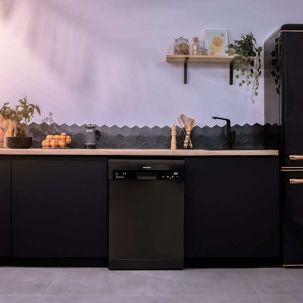 Un lavavajillas negro en una cocina moderna con gabinetes negros y una encimera de madera.