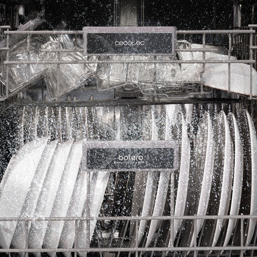 Dentro de un lavavajillas con platos y vasos. Agua rociando desde arriba. Platos brillantes.