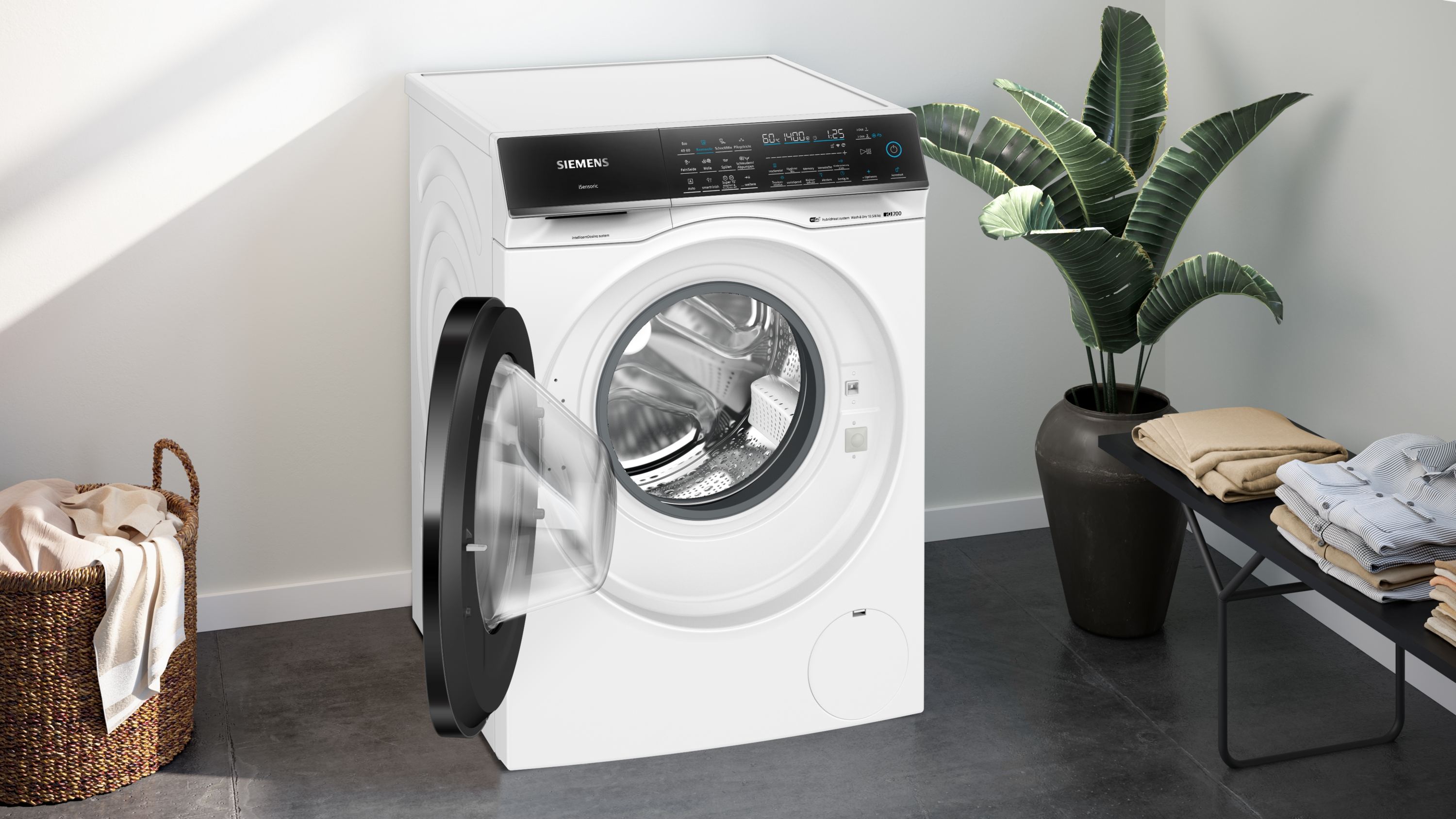 Eine weiße Siemens Waschmaschine mit offener Tür, neben einem Korb.