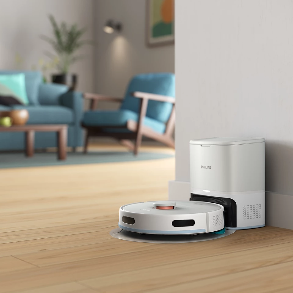 Egy robotporszívó fa padlót tisztít, a sarokban egy töltőállomással.