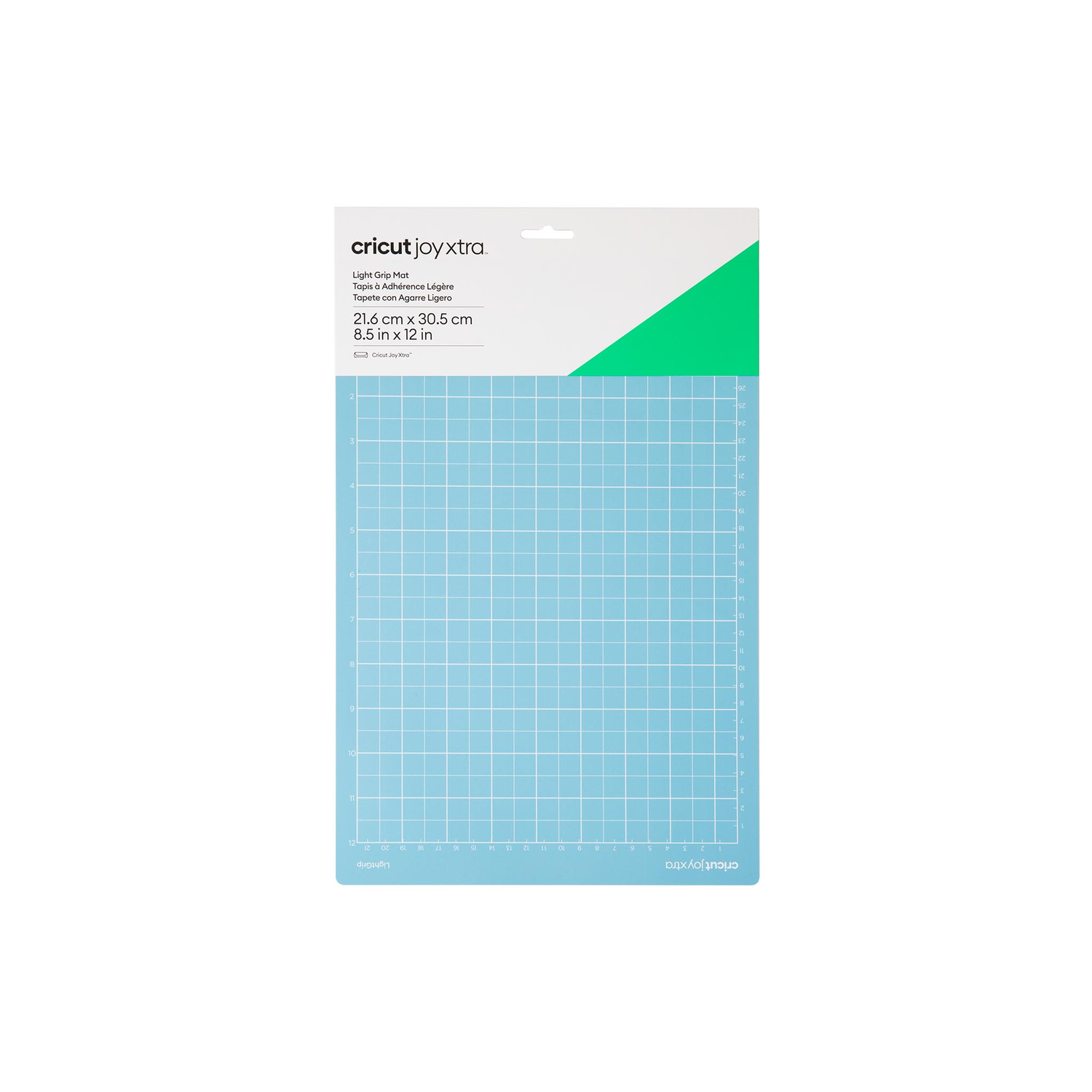 A blue cutting mat with a white grid and a green corner. White background.
