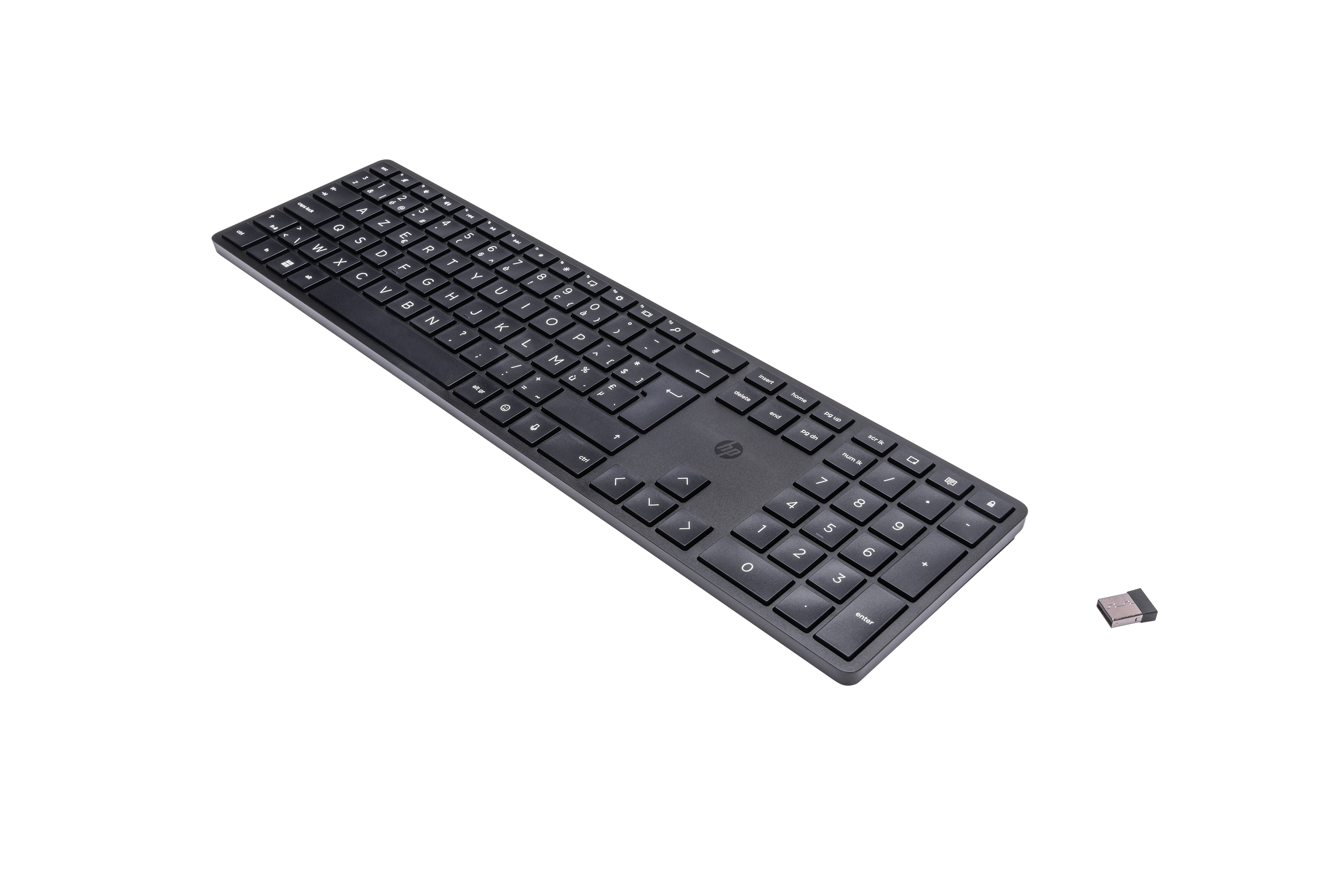 A black HP keyboard on a black surface. A small USB receiver is next to it.