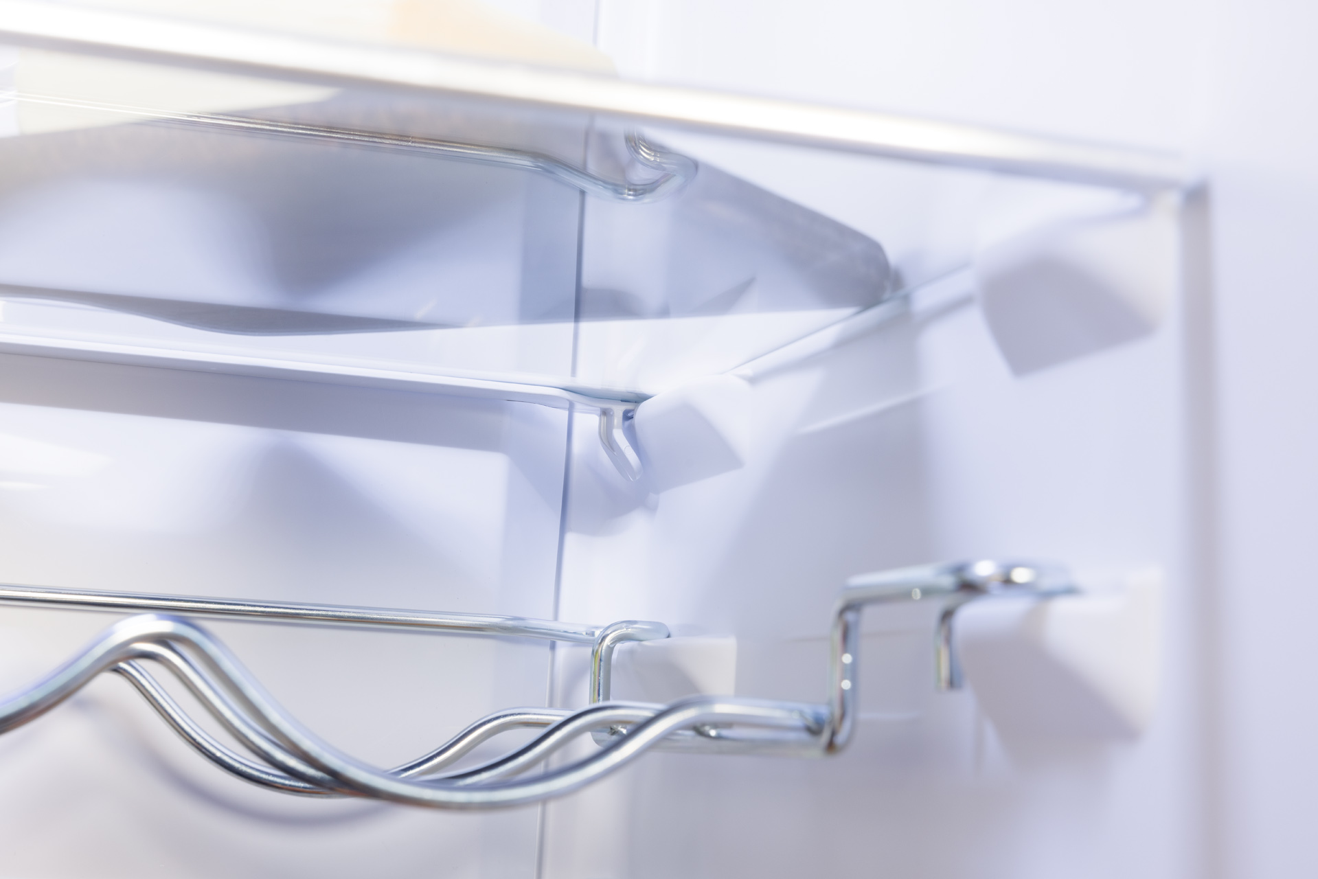 Wnętrze lodówki z metalowym stojakiem na wino.