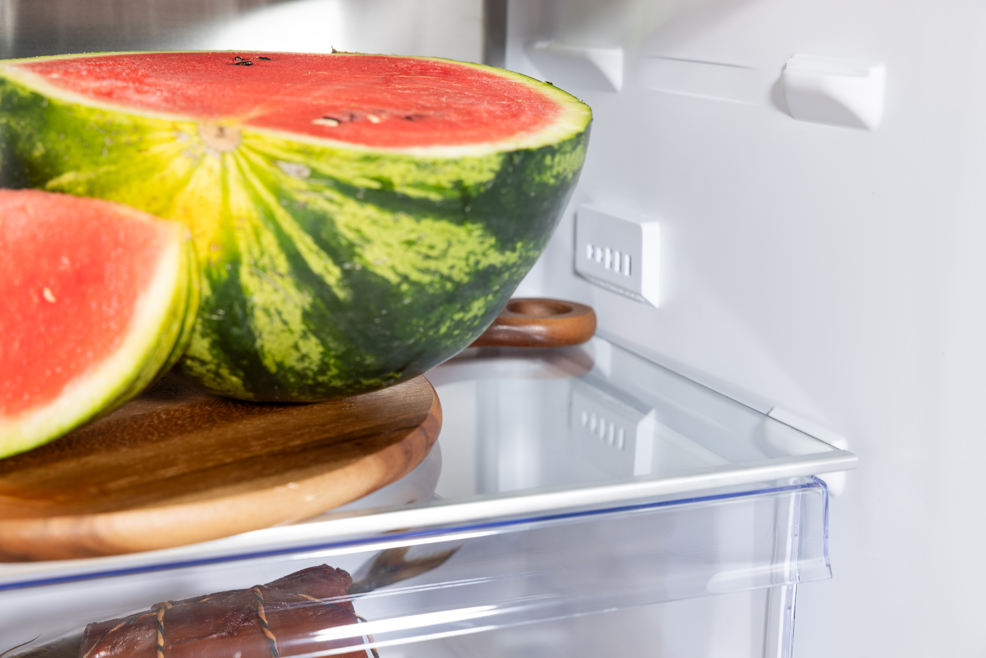 Kawałki arbuza i deska do krojenia w lodówce. Kolory zielony i czerwony.