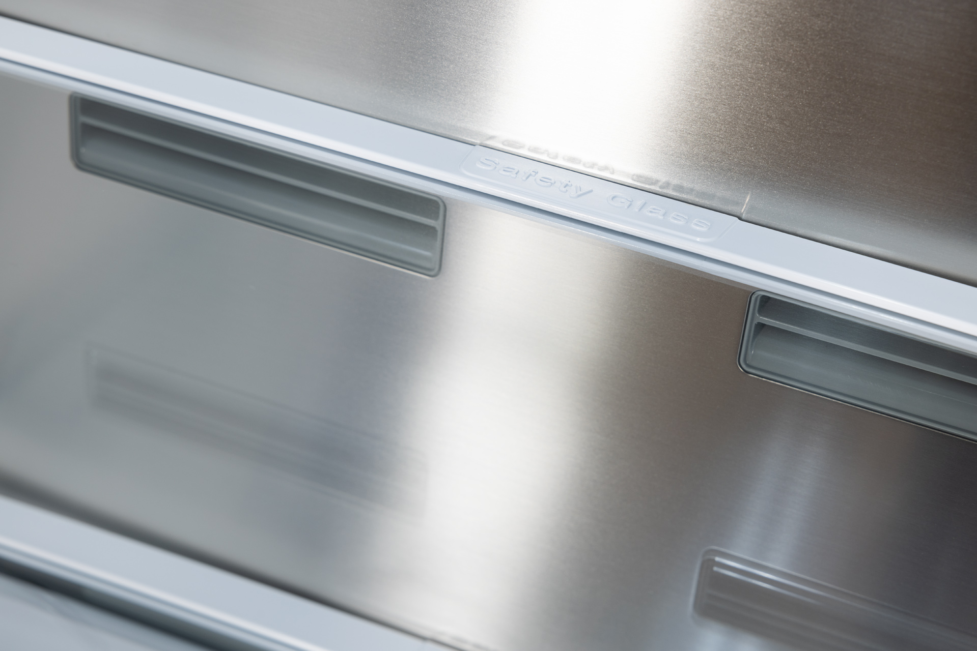 Zbliżenie wnętrza lodówki ze stali nierdzewnej ze szkłem bezpiecznym.