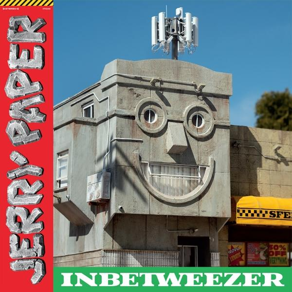 Ein Gebäude mit einem Gesicht. Das Dach hat einen Mobilfunkturm. Das Bild ist ein Albumcover.