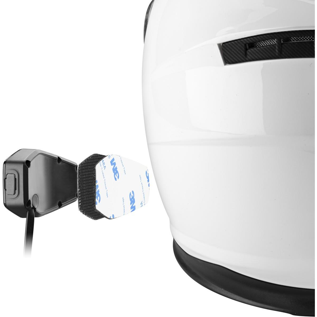 Helm mit angebrachtem Gerät. Das Gerät hat ein Klebepad und einen Knopf.