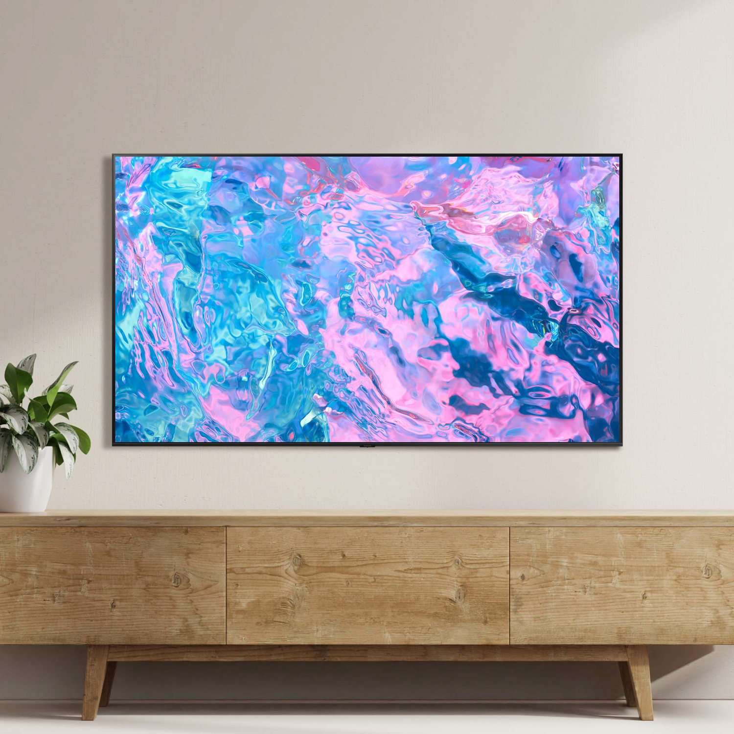 TV su mobile in legno, mostra motivo astratto blu e rosa. Parete bianca.
