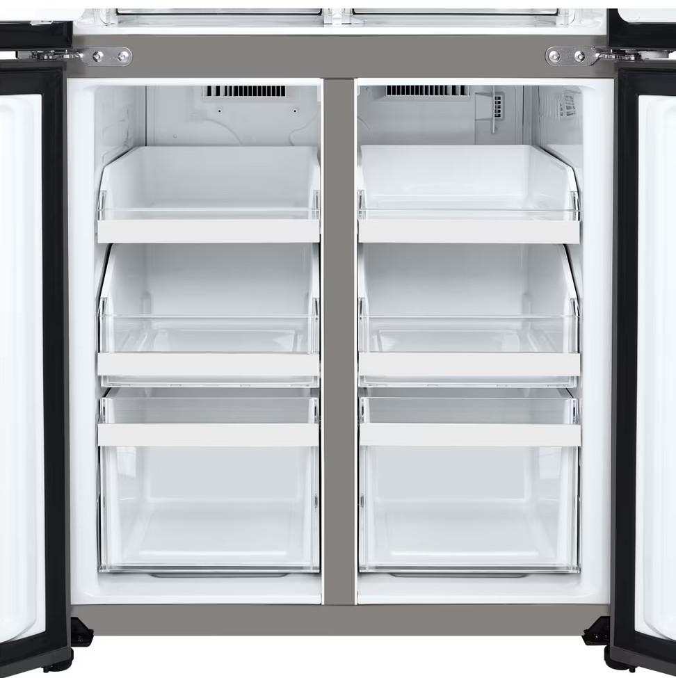 Otwarta lodówka pokazująca wnętrze z szufladami i półkami, wszystko puste.