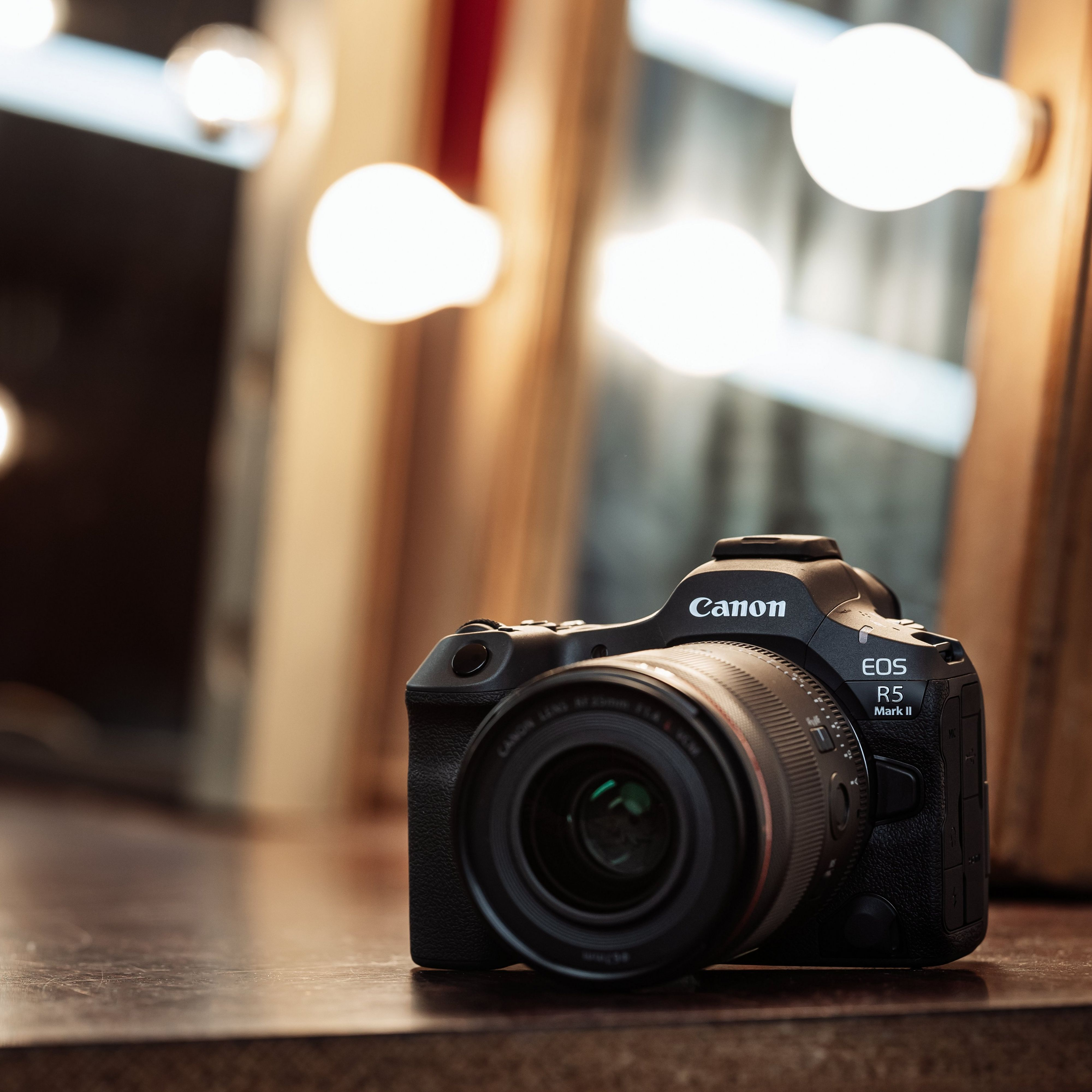 Appareil photo Canon EOS R5 Mark II sur une table, en studio, lumières en arrière-plan.