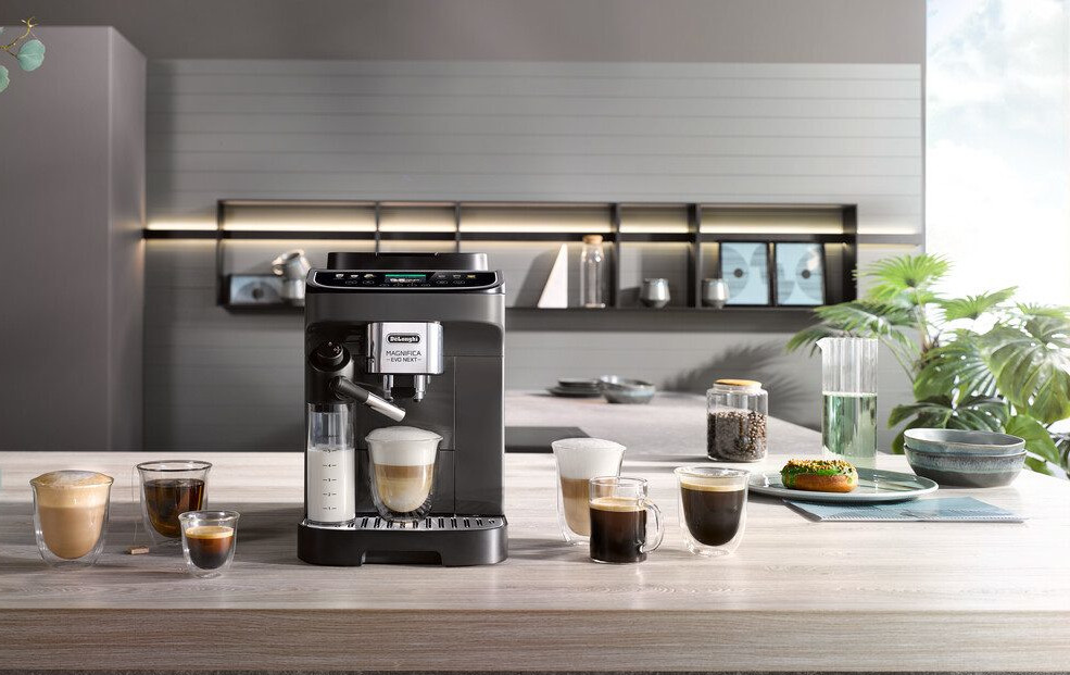 Czarny ekspres do kawy z filiżankami do kawy, szklankami i innymi akcesoriami na stole.