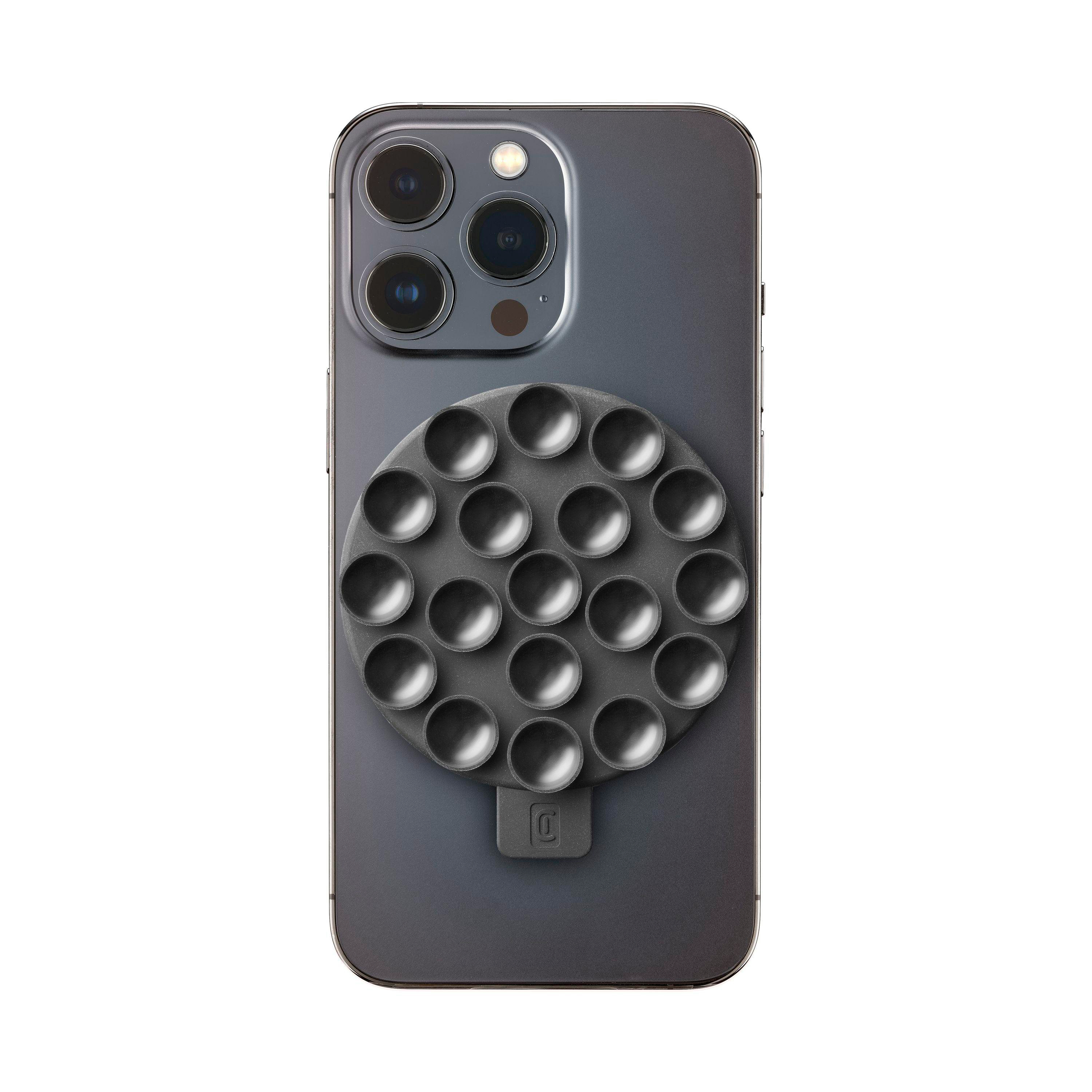 Ein Telefon mit einem schwarzen kreisförmigen Aufsatz auf der Rückseite. Der Aufsatz hat kleine Saugnäpfe.