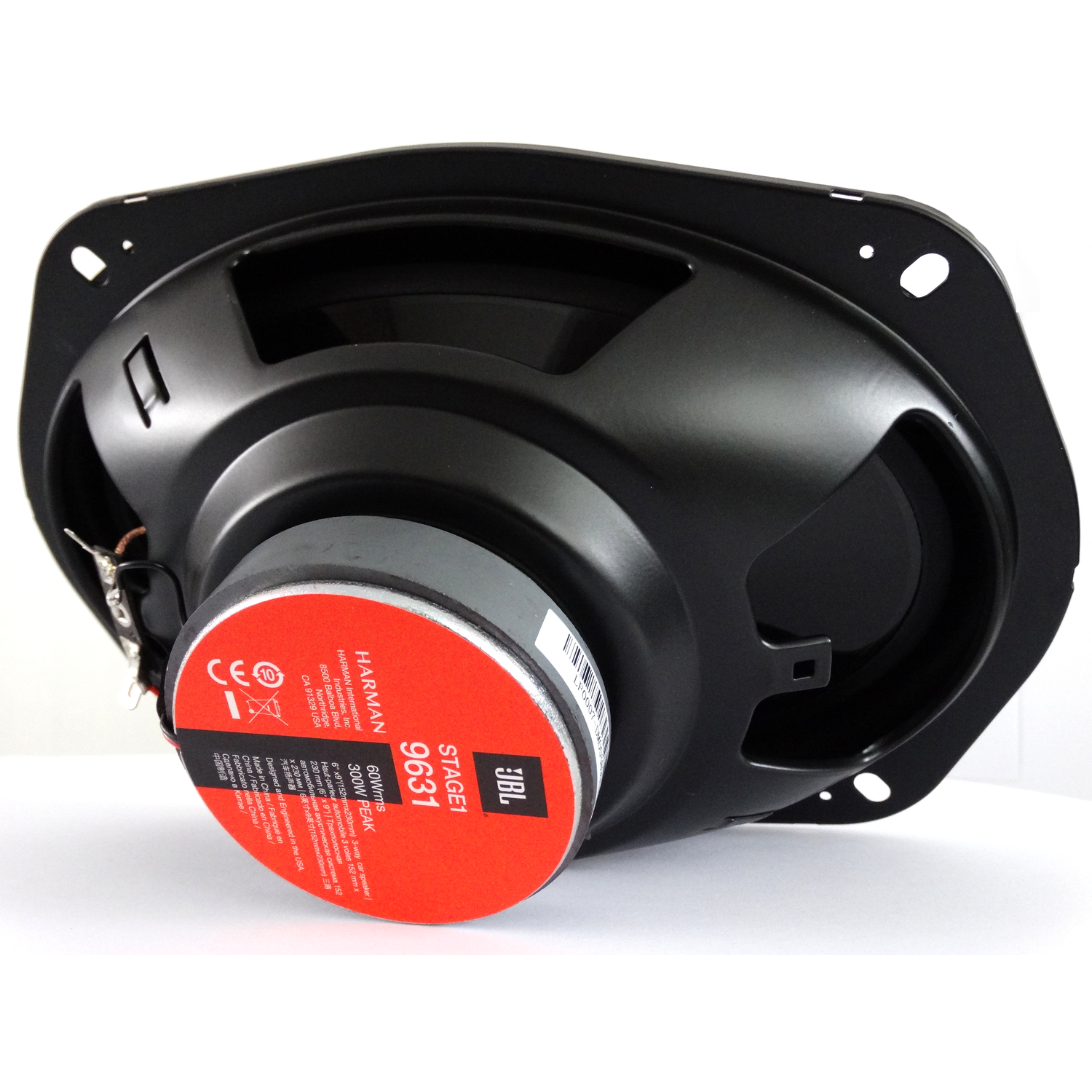 Zwarte JBL-luidspreker. Rood label met witte tekst. De luidspreker staat op een wit oppervlak.