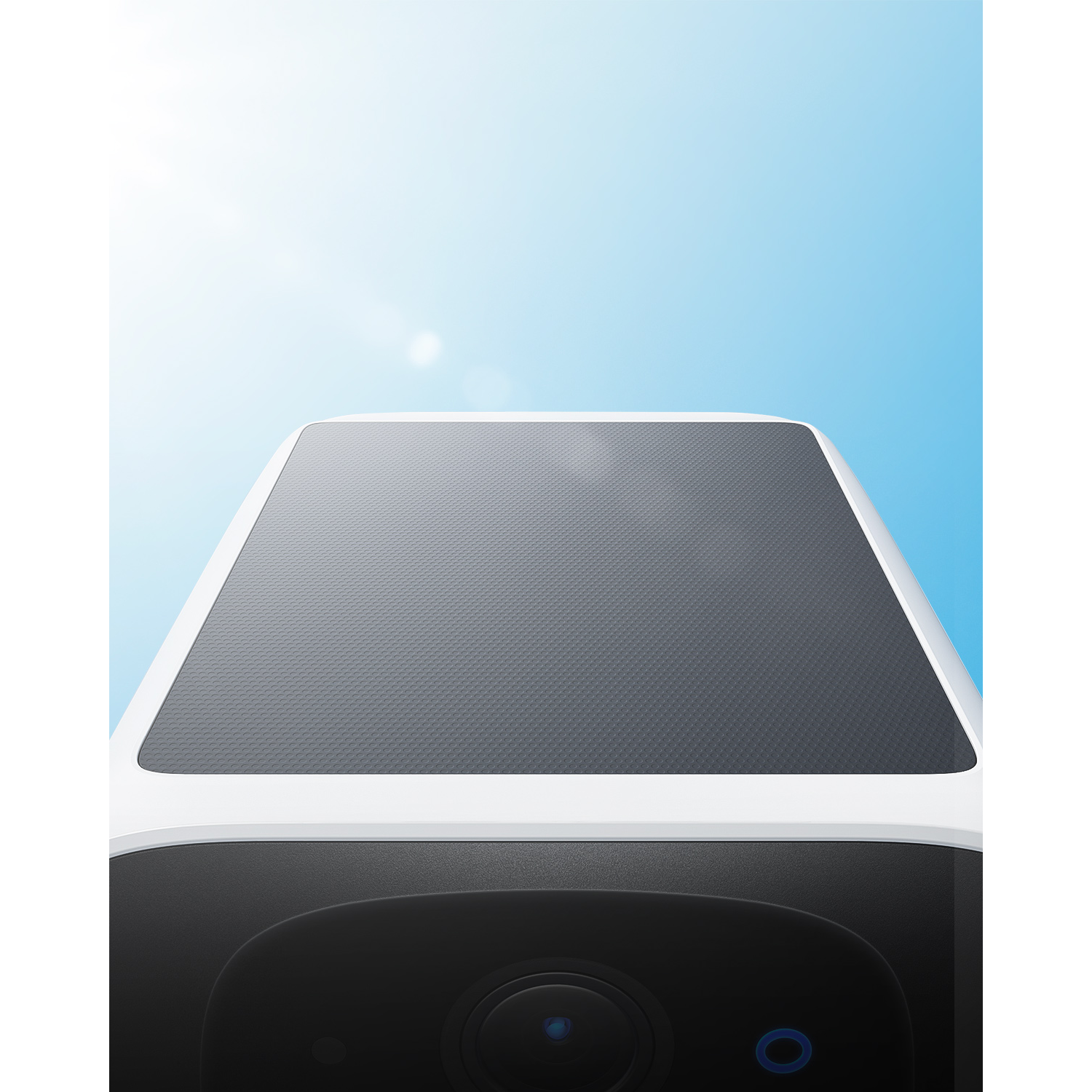 A top view of a security camera against a blue sky.