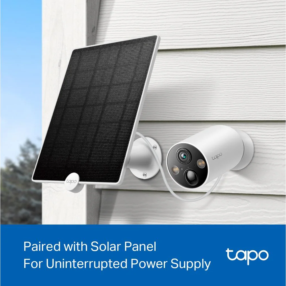 Eine weiße Überwachungskamera und ein Solarpanel sind an einem weiß getäfelten Gebäude befestigt.