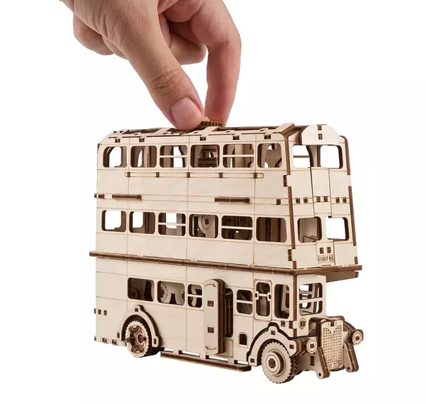 Egy fából készült emeletes busz modell, egy kéz a felső tetőt tartja.